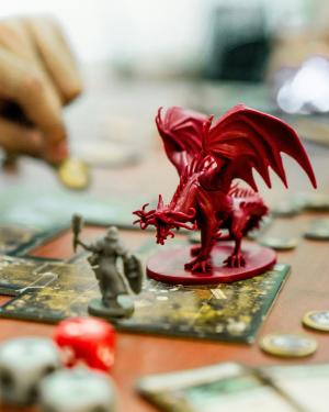 image of a tabletop roleplayer moving a token near a plastic dragon figure
